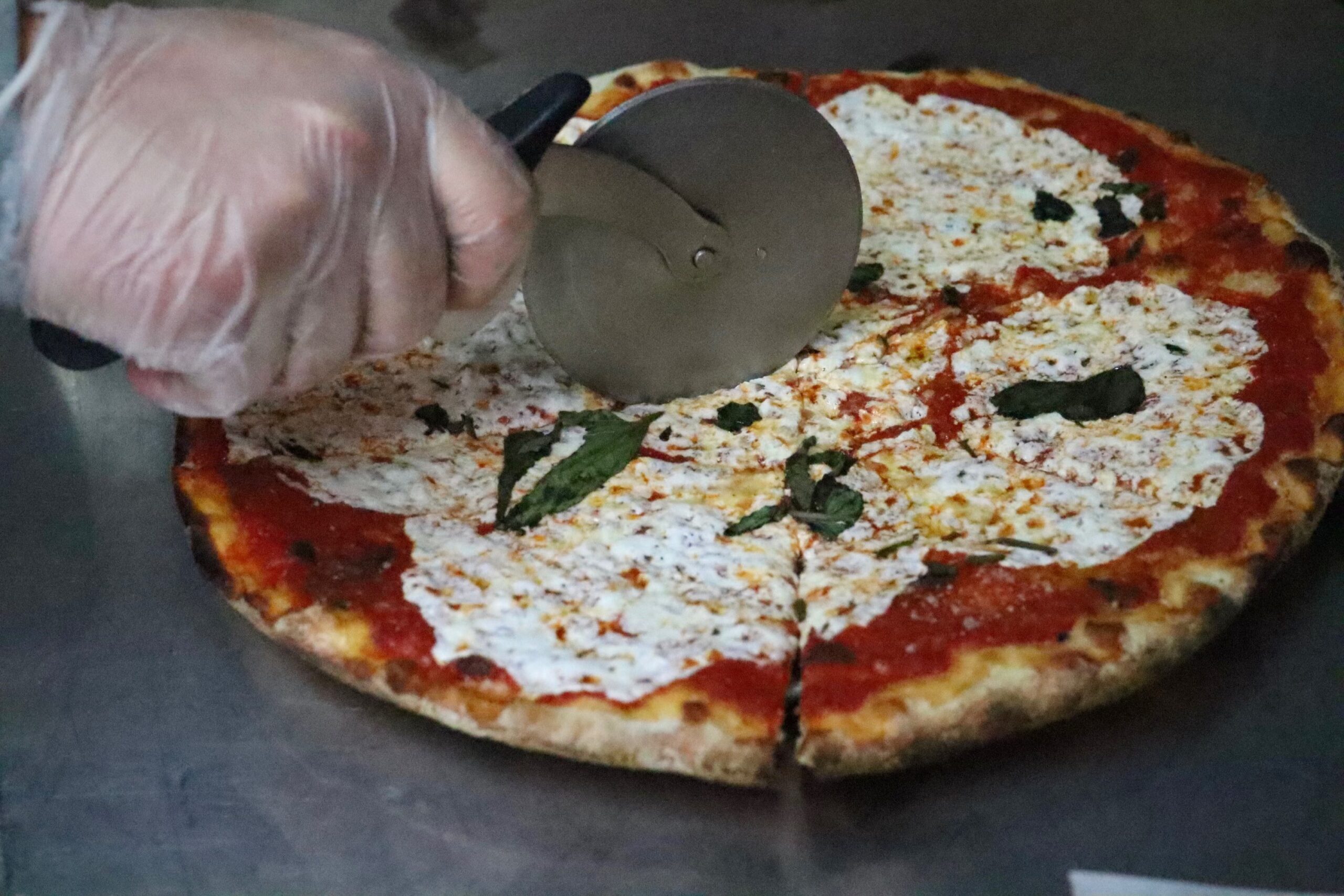 cutting margherita pizza