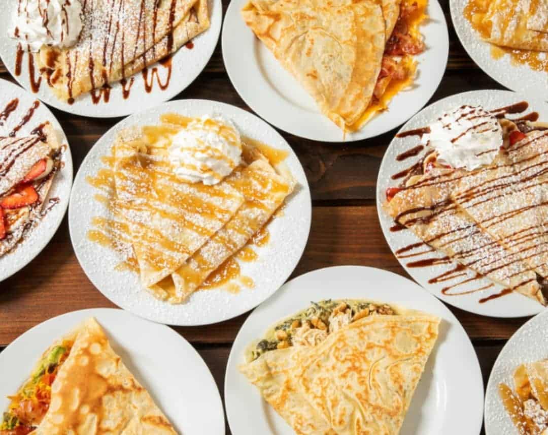 Variety of crepes displayed on a wooden table