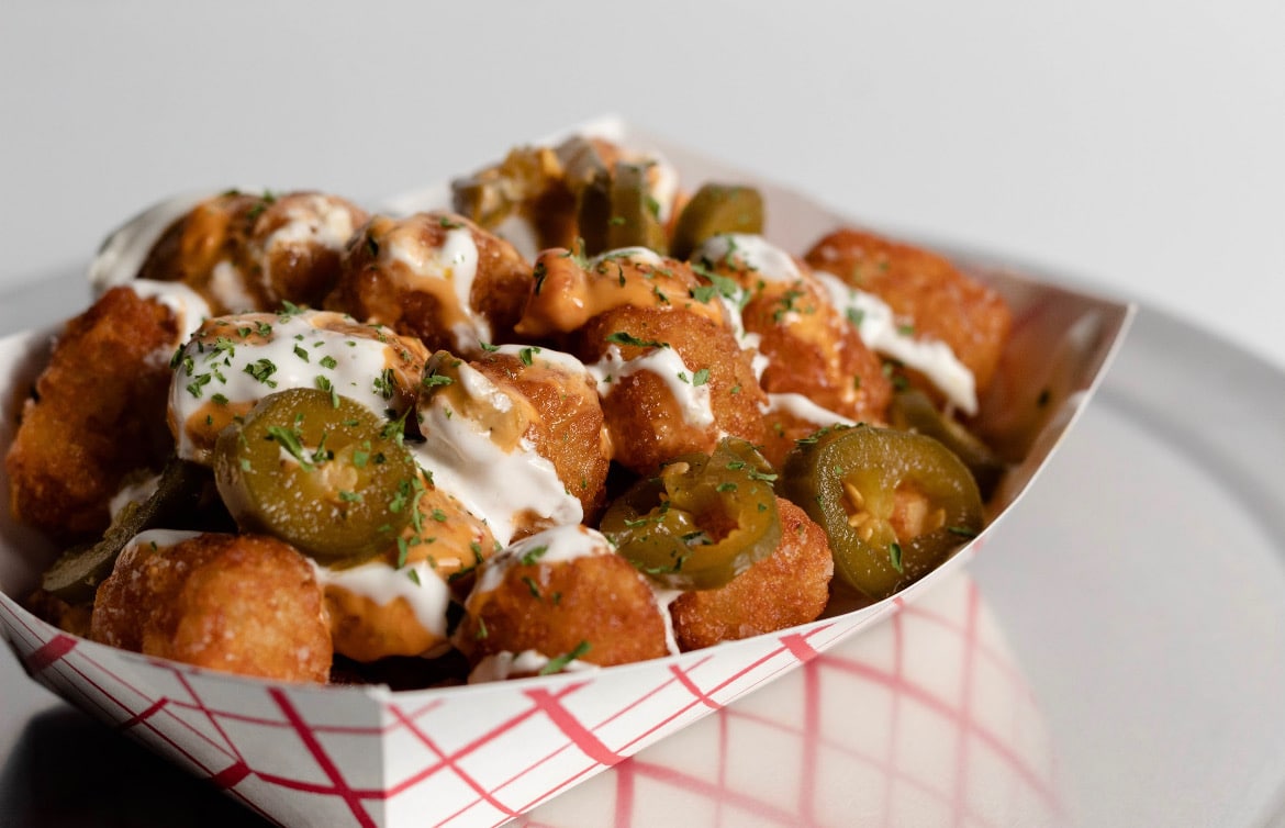 Tater tos, queso, Chimi aioli, pickled jalapeños, lime crema, dusted takis