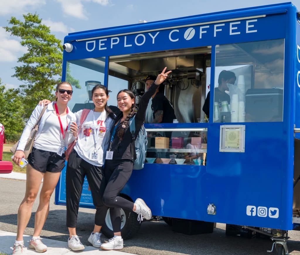 three people in front of deploy coffee