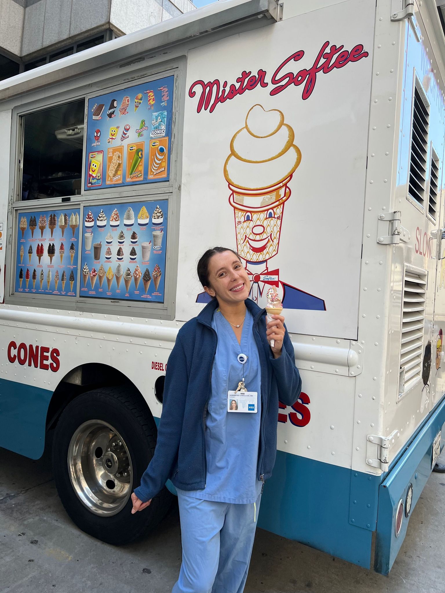 HSS employee holding ice cream cone in front of Mister Softee ice cream truck