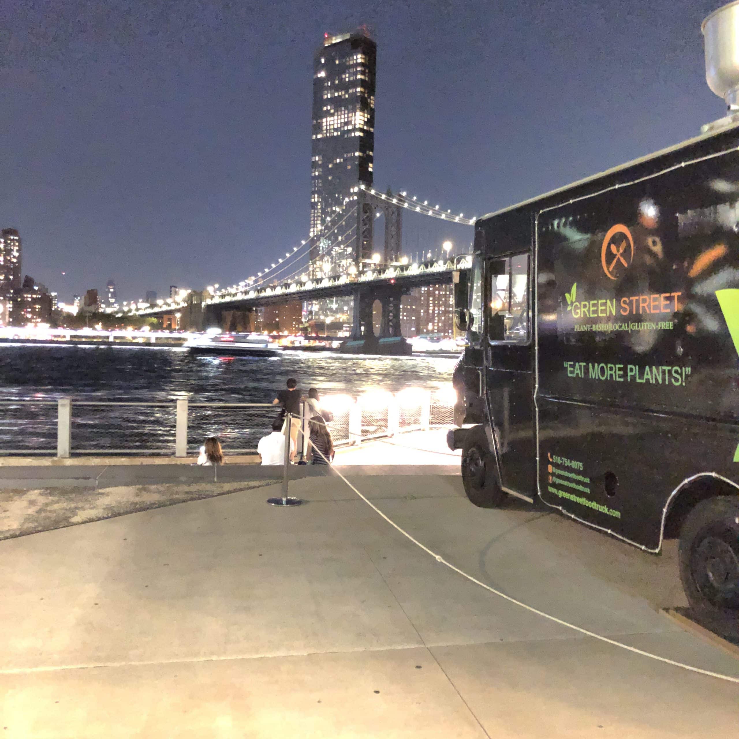 green street truck at night with bridge in background